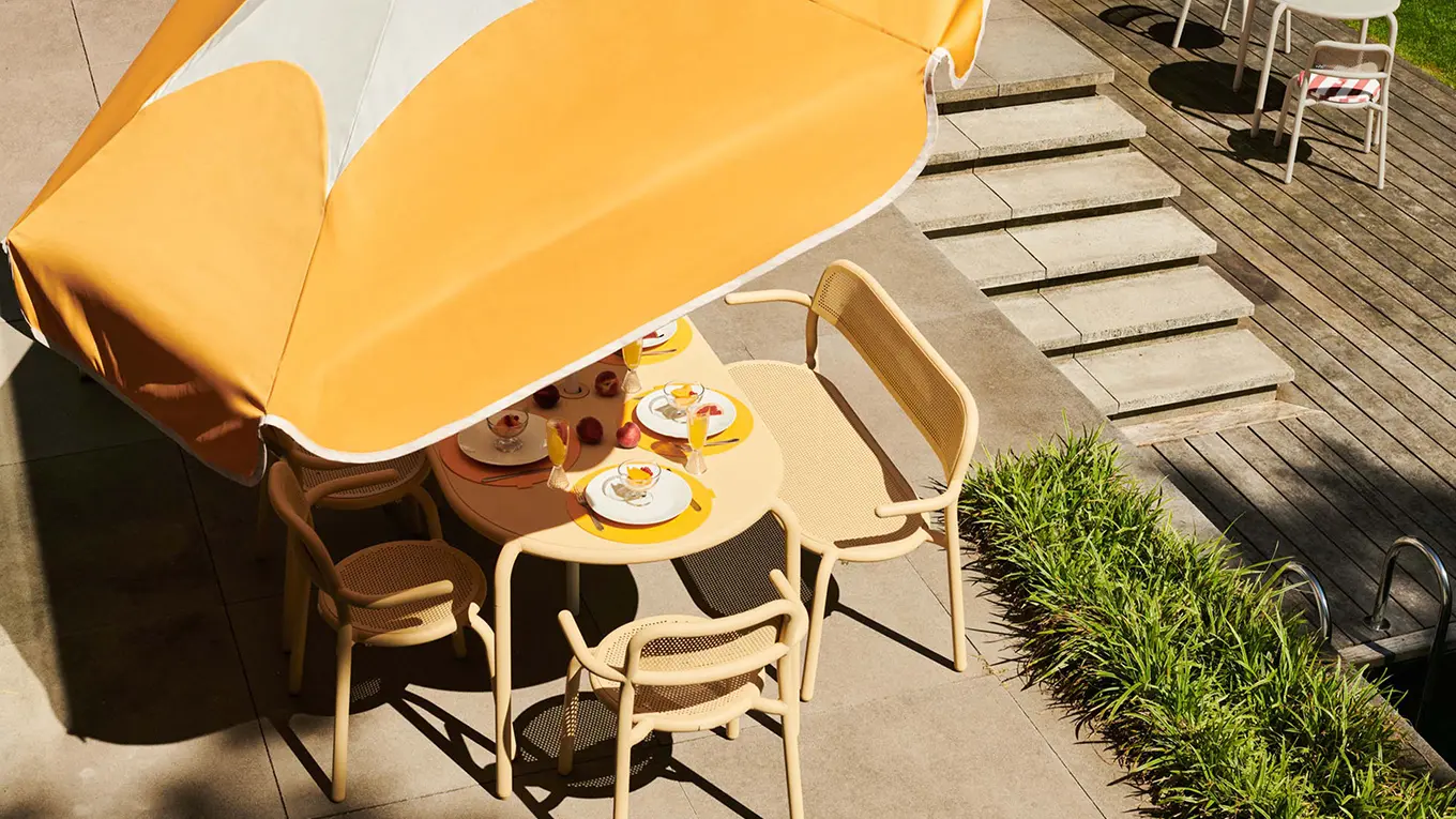 Orangefarbener fatboy sonnenschirm sunshady überm esstisch
